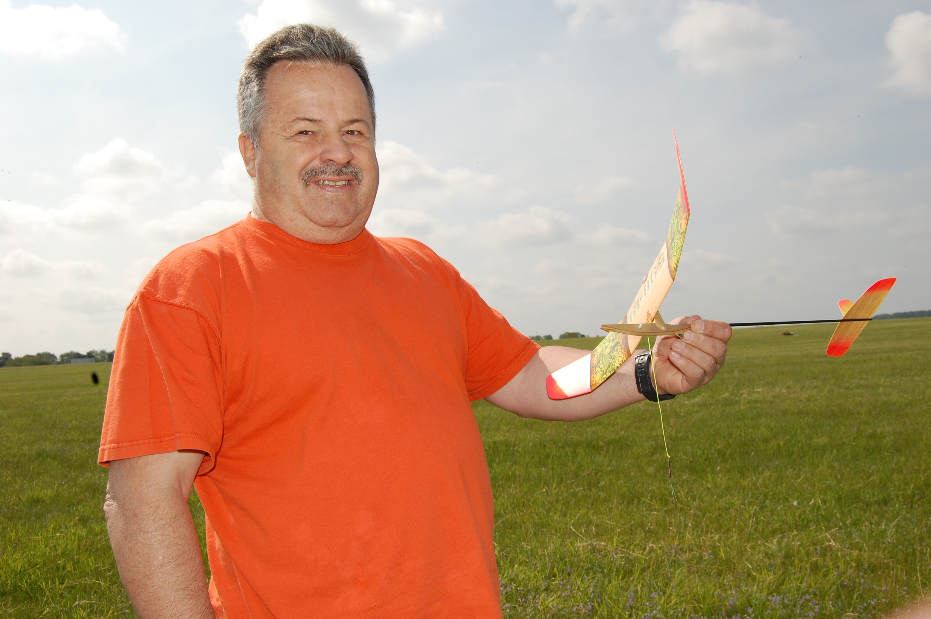 Bruce Kimball, here again from the USA, holding his winning Catapult Glider. Brought several in a special box that fits in the overhead luggage space on air flights. displaying tipping wing DT. Pivot at LE gives ‘tumbling pigeon’ descent from even strong lift. Uses ‘silly putty’ timer.
